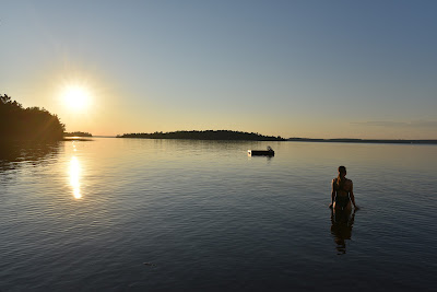 Sonya Richmond swimming in Northern Ontario lake with sunset.