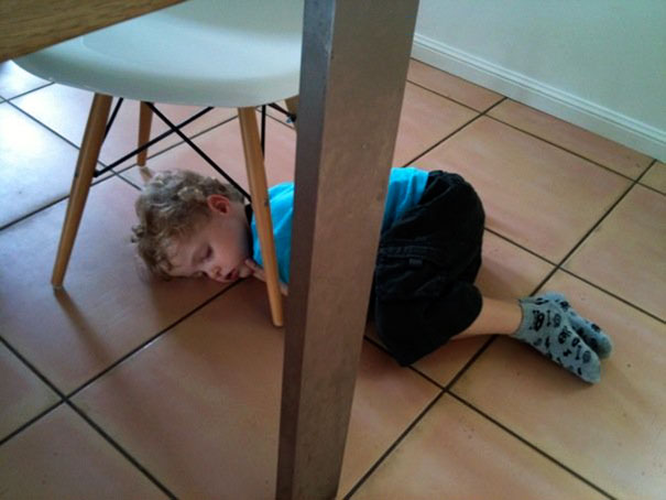 15+ Hilarious Pics That Prove Kids Can Sleep Anywhere - Napping On The Floor Under The Dining Table