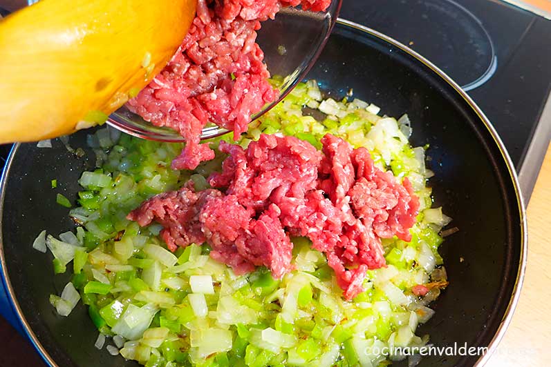 Mezclando en la sartén la carne con las hortalizas sofritas