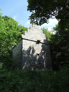 A photo of Rosyth Doocot - a large stone building standing amongst the trees.  Photo by Kevin Nosferatu for the Skulferatu Project.