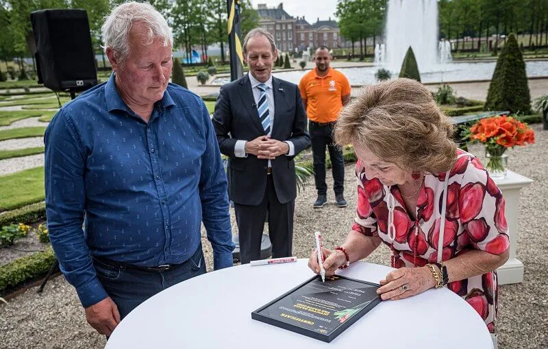 Princess Margriet wore a red floral print dress and red pumps, red earrings, carried white bag