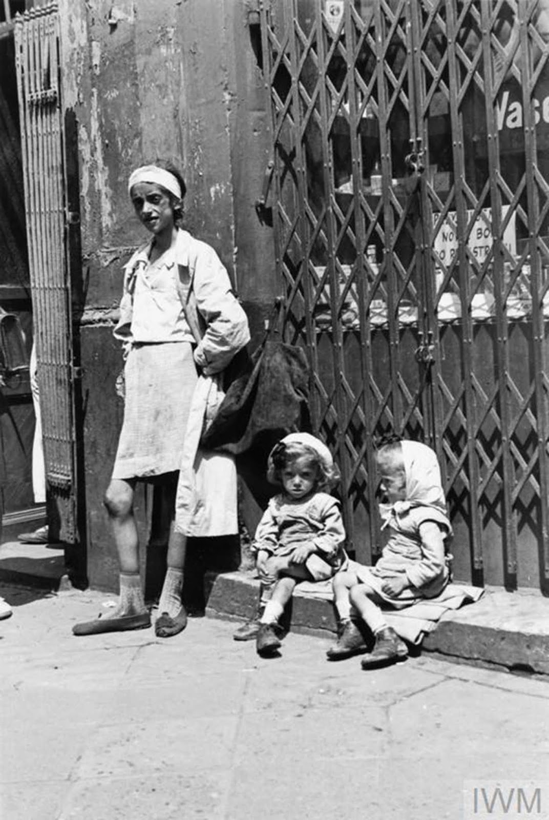 An emaciated mother with her twin daughters in the ghetto, summer 1941.