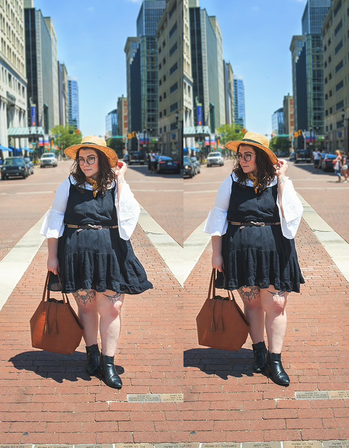 An outfit consisting of a straw boater hat, a white off the shoulder ruffle neck hem blouse, black tiered camisole dress, and black heeled chelsea boots.