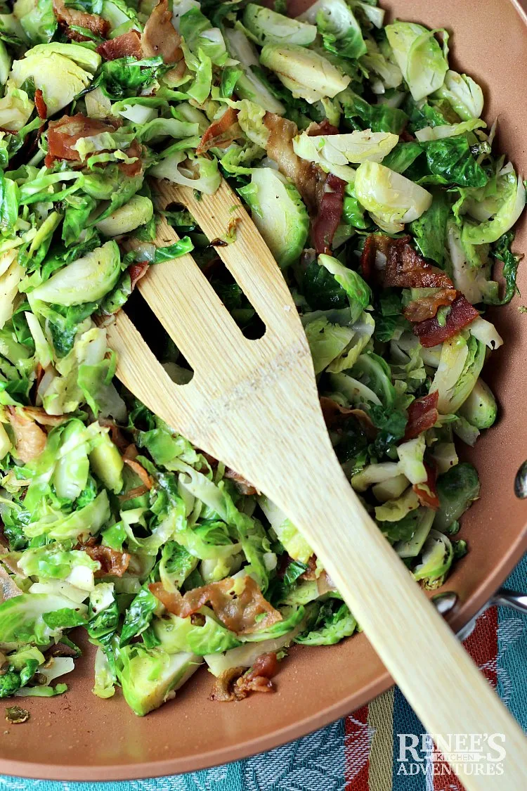 Overhead view of Sauteed Brussels Sprouts with Bacon by Renee's Kitchen Adventures in pan with wooden spatula image