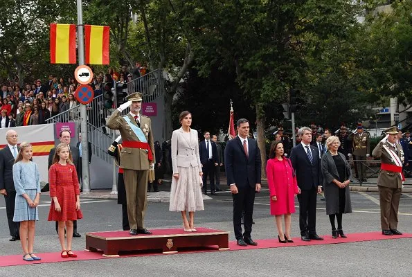 Queen Letizia wore Felipe Varela coat and dress. Crown Princess Leonor and Infanta Sofia attended National Day 2018 parade held at Plaza de Lima