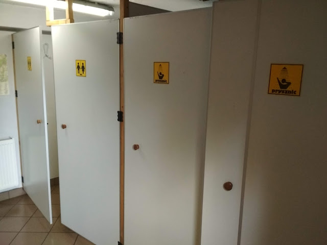 Widok na sanitariaty czyli prysznice i toalety na polu namiotowym Przystań Kowale.