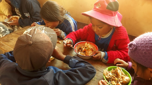 Das Dorf bereitete ein schmackhaftes Mittagessen mit Hähnchen vor. Allen schmeckte es. Da spielte es keine Rolle, wenn man auf dem Boden sitzen musste und den Teller auf dem Schoss hatte.