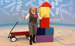 Ms. Noodle stacks the blocks and places the triangle on the top piece. Sesame Street Elmo's World Building Things The Noodle Family