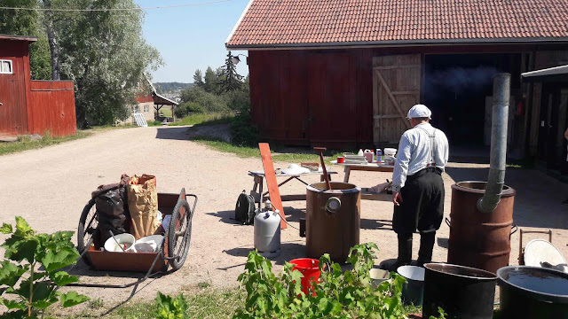 Kärryssä punamullan valmistusaineita, etualalla mies ja tynnyreitä.