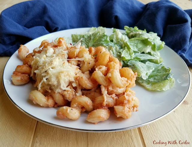 plate with chicken cheese and pasta casserole with lettuce salad