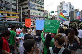 young women hold signs that say "Follow Your Heart" and "Equal Love" at 2011 Taiwan LGBT Pride Parade