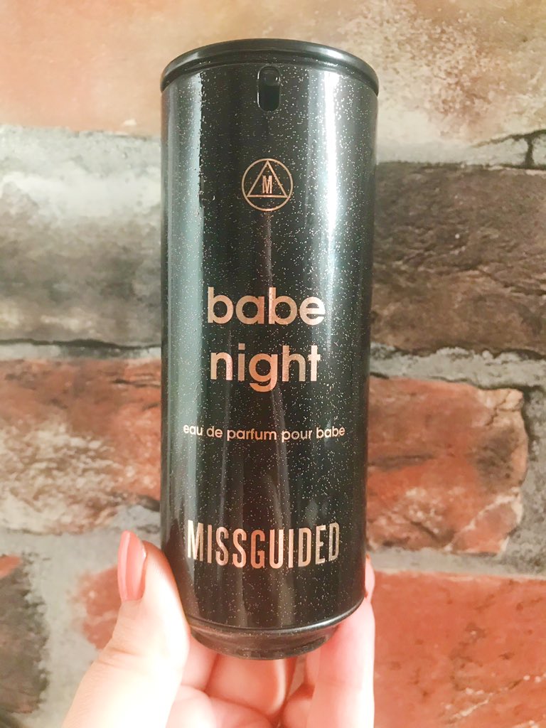 Missguided Babe Night Perfume held up in front of brick wall