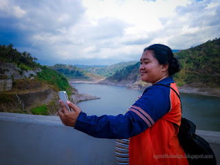 Woman Traveler Taking Selfie With Her Smartphone On The Largest Titab Ularan Dam In Bali Indonesia