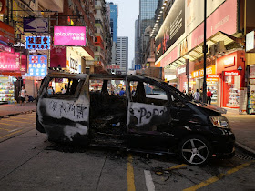 burned vehicle with ""便衣狗車" written on it