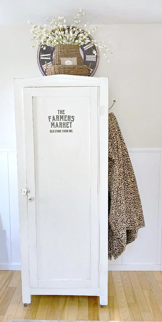 Finished white cupboard with hook and leopard throw.
