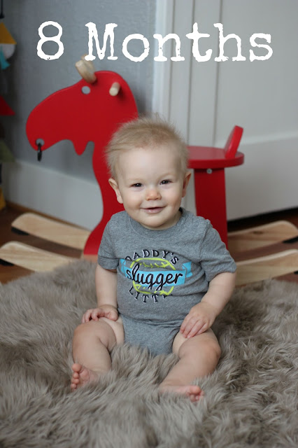 Little boy smiling in front of red rocking toy image.