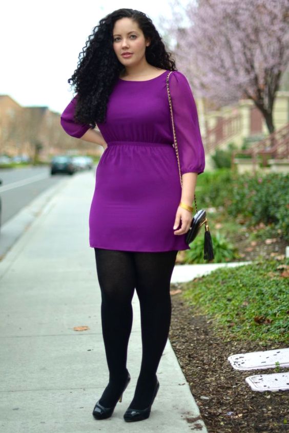 Plus size woman wearing a purple mini dress, black tights and black high heels