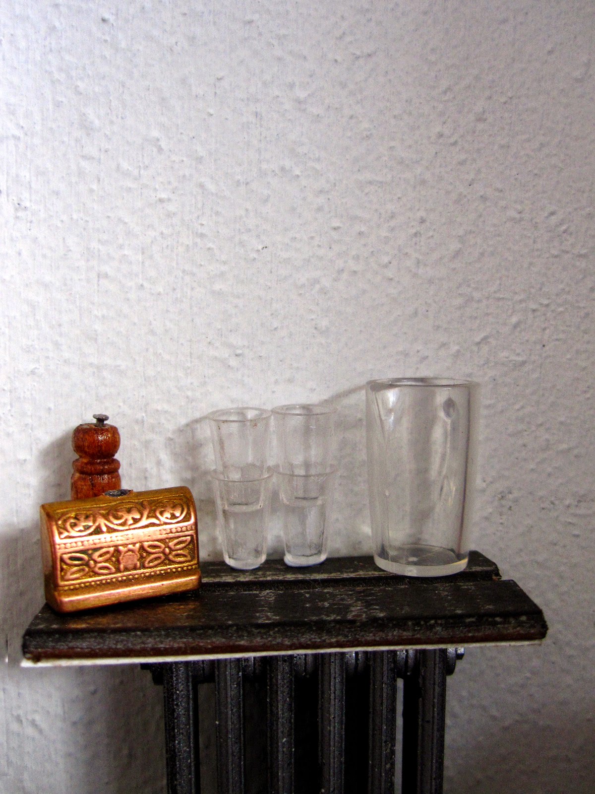 Modern dolls' house miniature cafe water shelf with jug and glasses, pepper grinder and sugar bowl in the shape of a treasure chest.