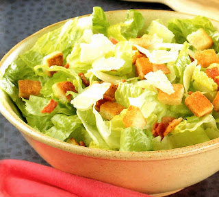 Caesar Salad: Classic Caesar salad served in a cream bowl