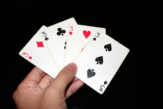 Hand holding all 3s in a deck of playing cards
