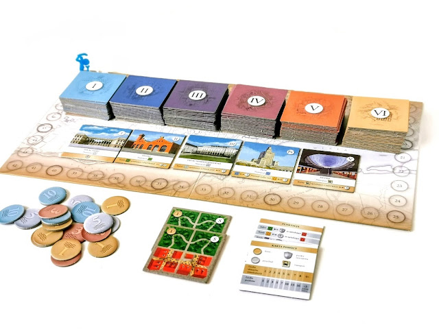 zdjęcie przedstawia elementy przygotowane do gry, plansze z torem punktacji a na nim kafle miasta,obok żetony monet i kafle startowe