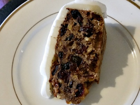 A slice of Christmas cake on a white plate.