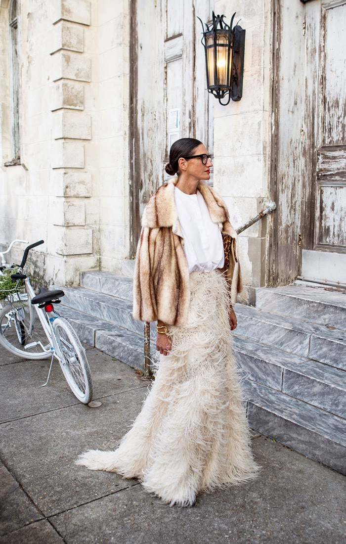 Jenna Lyons, the creative director and president of J.Crew stands outside the wedding of Beyonce's sister Solange Knowles in an all white ensemble besides a cycle and flowers