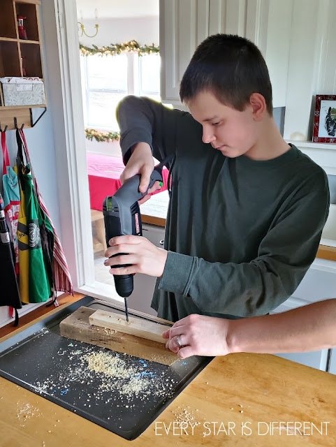 Drilling holes for candles in a homemade Kwanzaa Kinara