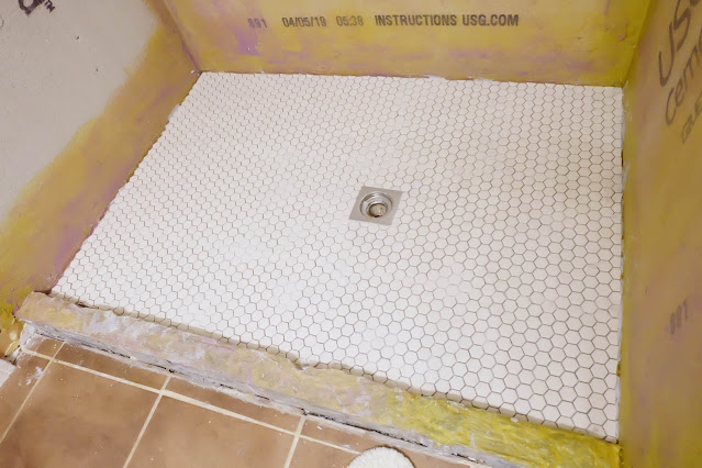 finished shower floor with unglazed hex mosaic tile
