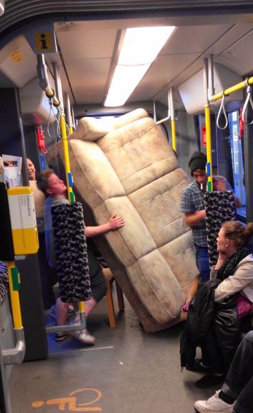 Witzige Frau in Straßenbahn - Couch transportieren