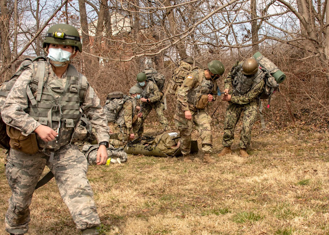 Students photographed in the woods during the Gunpowder medical field practicum. All of the students are in masks as a COVID precaution.