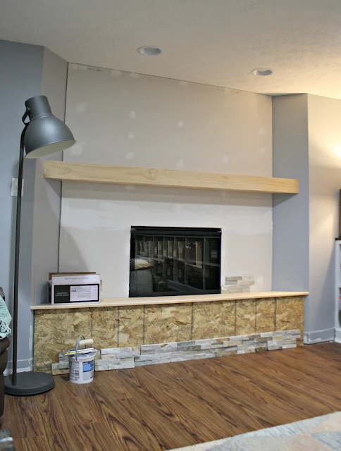 basement fireplace with hearth and mantel