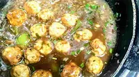 Cooking chicken balls in manchurian gravy in a pan