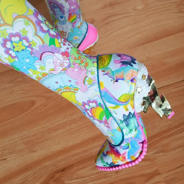 close up of foot with care bear tights and lightning bolt heeled dinosaur themed shoe