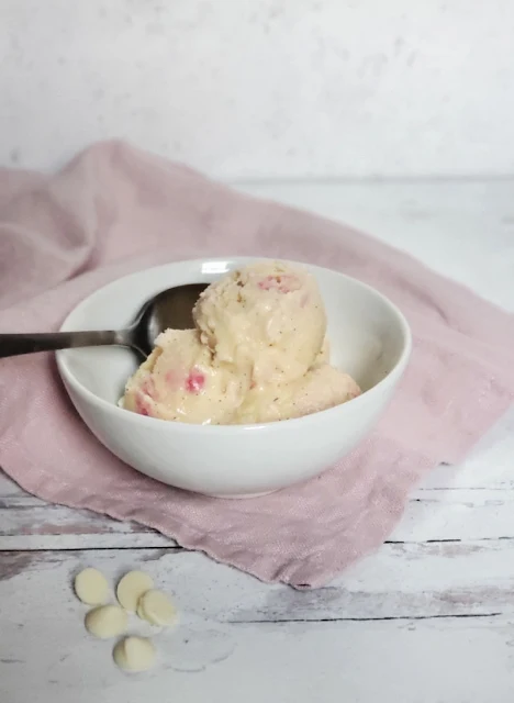 raspberry white chocolate ice cream in bowl with spoon