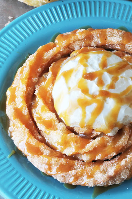 Inspired by Disneyland's delicious Churro Funnel Cakes, this is an easy and decadent dessert. Spiral churro goodness topped with freshly whipped cream and drizzled with caramel sauce.