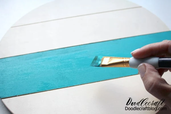Step 1: Paint!   Begin by painting the lower half of the sign. I followed the slat lines, so it was super easy. If you have a solid round circle, just use painters tape to mask off a straight line. Then paint the lower half.   I picked a charming turquoise, which feels like Fall to me...but pick whichever color you love.