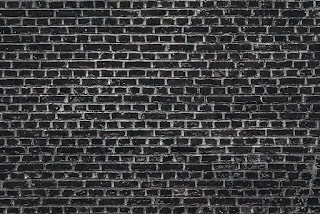 A high contrast black and white photograph of a brick wall, highly textured, the bricks are black, the mortar white, set in the English Bond pattern of alternate rows of stretchers and headers.