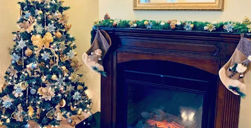 Nicely decorated Christmas tree next to a fireplace with a DIY garland.