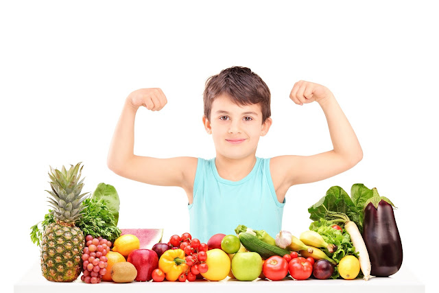طفل يتظاهر بقوة عضلاته امام الخضروات والفواكه