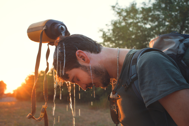 Man cooling down by pouring water over his head