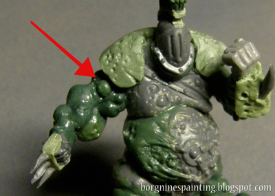 Picture showing the finished conversion, with a red arrow pointing to the small greenstuff ball that was pressed into the arm before it cured, creating a simple boil.