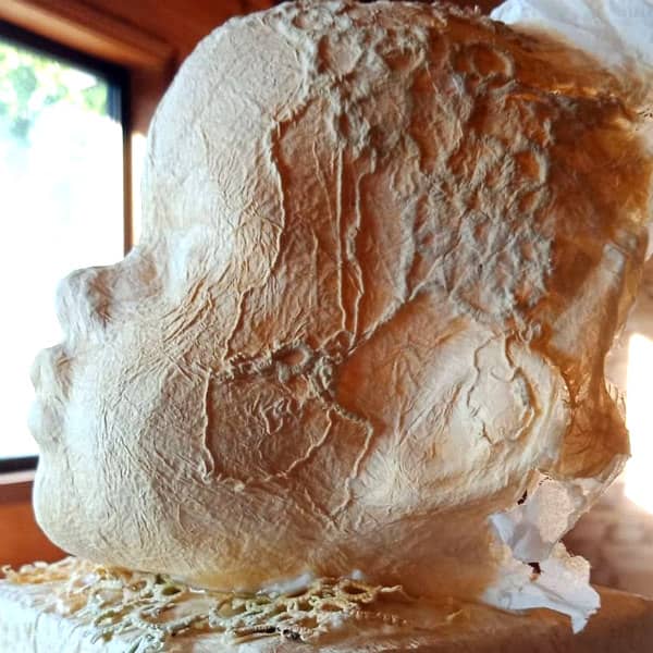 In progress tissue paper baby's head sculpture