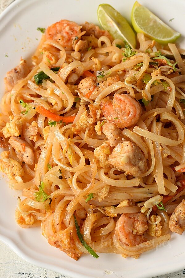 close up of a white plate with shrimp,eggs,chicken and veggies loaded authentic pad thai recipe