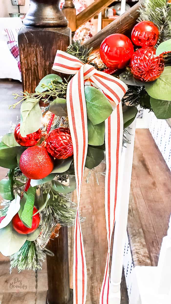 red and cream striped ribbon tied to garland with long tails