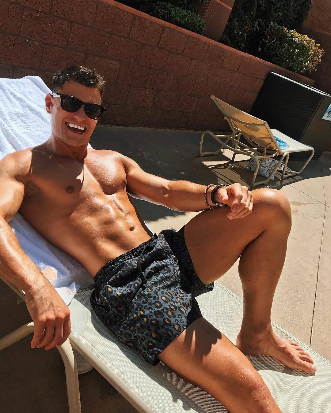 handsome-bare-chest-fit-hunk-sunglasses-smiling-sun-tanning