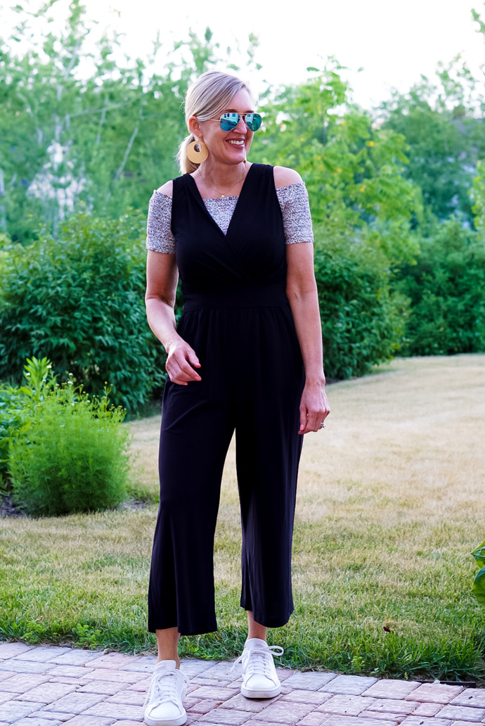A woman wears a smocked top under a casual black jumpsuit, one of three ways to wear a black jumpsuit