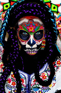 La Muerta by Fer Gomez on Unsplash Close up of a woman white black and purple braids and an elaborately painted face. La Muerta by Fer Gomez on Unsplash.