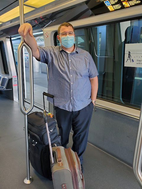 Image of man standing wearing a mask on board a tram car
