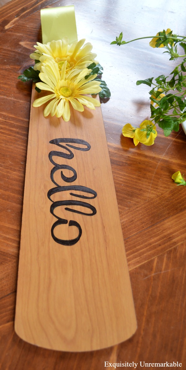 Wooden Fan Blade Hello Sign with yellow flowerson table